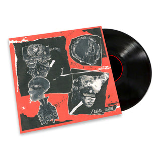 A vinyl record partially pulled from its sleeve, shown on a plain white background. The sleeve has a vivid red border with black collage artwork and the text 'ABASE - LARDE' visible.