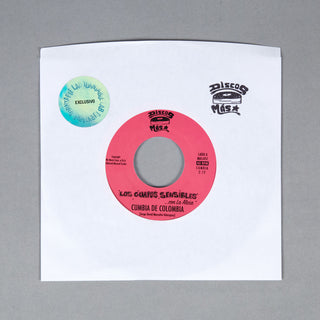 Vinyl record sleeve for 'Los Gafas Sensibles - En La Mesa' by Cumbia de Colombia, featuring a pink inner label on a white sleeve with a blue-green exclusive sticker and a black 'Discos Maza' logo, photographed on a gray background.