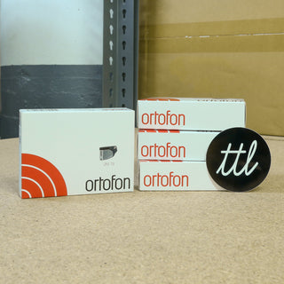 Two boxes with 'ortofon' branding and a black and white 'ttl' logo on a beige surface.
