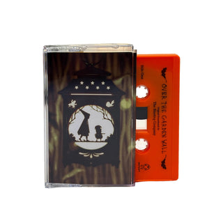 A cassette tape album in a clear plastic case with a black illustrated cover and an orange tape reel visible behind it, photographed on a plain white background.