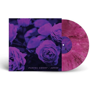 A vinyl record partially pulled from its sleeve, showing a dark purple floral album cover and a marbled pink record on a white background.