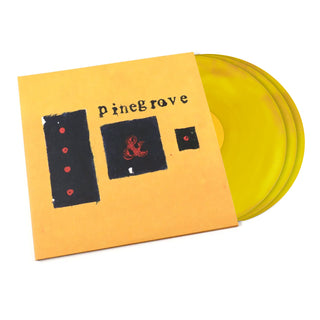 A vinyl record partially pulled from its sleeve, showing a translucent yellow disc behind a peach-orange sleeve with black graphic blocks and the text 'pinegrove'.