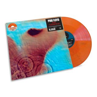 Pink Floyd 'The Dark Room' vinyl record with its illustrated album cover sleeve and a translucent orange record partially visible behind it on a white background.