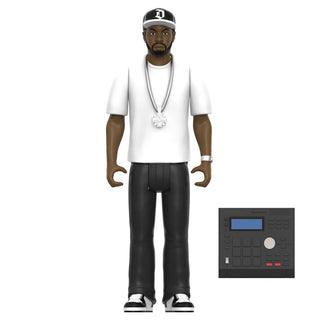A toy action figure of a man wearing a white t-shirt, black pants, a silver chain with a snowflake pendant, and a black baseball cap with a white 'D' logo. The figure is shown standing next to a small accessory panel depicting a black electronic music controller.