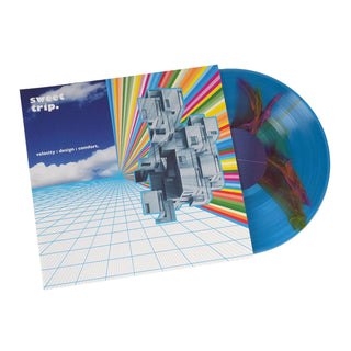 A vinyl record partially pulled from its sleeve, showing a blue translucent record with a colorful abstract cover and matching printed sleeve. Visible text on the sleeve reads 'sweet grip.