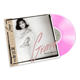 A vinyl record album shown at an angle with the sleeve partially pulled open, revealing a pink translucent record. The cover features a black-and-white portrait of a woman and the word 'Gravy' in large script, with 'Yasuro Adagawa' printed near the bottom right.